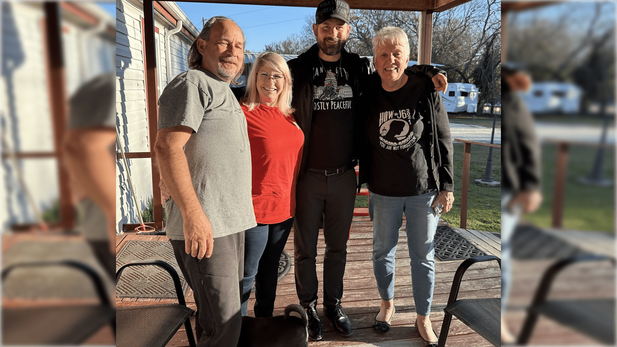 A group of four adults and a dog pose together on a porch, showcasing a sunny day and friendly atmosphere.