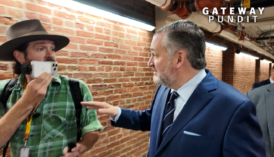 A journalist captures a moment with a politician in a brick corridor, highlighting a candid interaction during a public event.