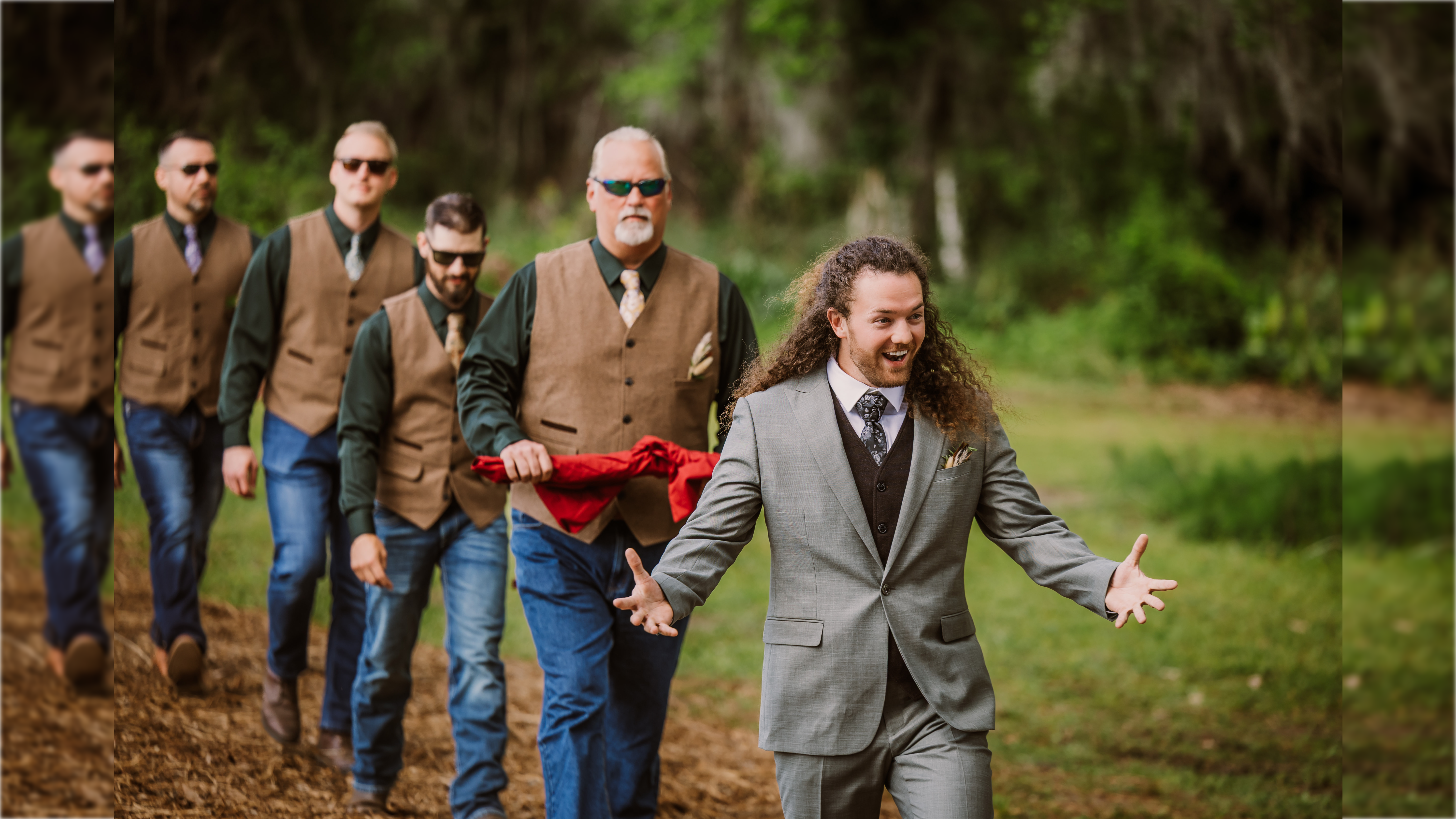 Groom and groomsmen in stylish attire walking together outdoors, showcasing a joyful and relaxed atmosphere during a wedding ceremony.